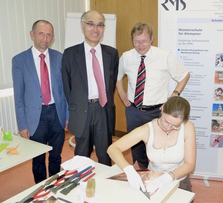 Die Ehrengäste beobachten Claudia Pflug beim Kranichfalten
