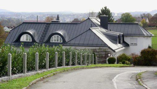 <p>
 Projekt 2 perfekt im Schwung: Formschön gehen die Stehfalze vom Hauptdach in die geschwungenen Dachgauben über
</p>