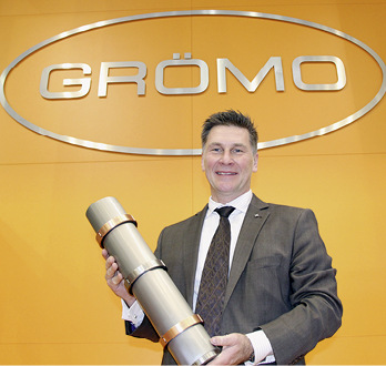 Jörg Abfalter zeigt ein Regenrohr mit neuartigen Design-Fallrohrschellen
