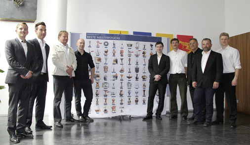 Die Ulmer Meister und Ausbilder Bernd Kramer (3. v. r.) vor dem BAUMETALL-Plakat der besten Meisterstücke
