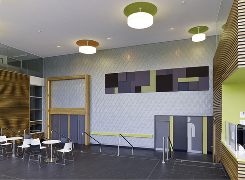 
Fortsetzung des Materialthemas Titanzink im Gebäudeinneren: Die Wand mit Spitzrauten als Eyecatcher im Foyer
