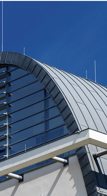 Zinkprofile am Giebel vollenden das Design des Metalldachs, welches aus der Fassade zu wachsen scheint
