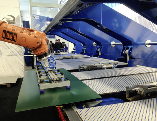 Ein Roboter bestückt den Variobend-Doppelbieger und entnimmt das fertige Profil nach dem Biegevorgang
