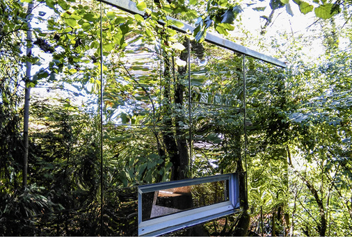 
Effekt-Fassade. Nur das Fenster lässt erkennen, dass es sich um ein Spiegelbild handelt. Die verspiegelten Edelstahltafeln haben eine Dicke von 0,8 mm
