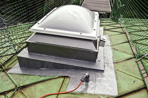 
Nachträglicher Einbau einer RWA-Anlage in ein bestehendes Metalldach: Die Abdichtung erfolgte mit einkomponentigem Flüssigkunststoff. Sie ist auch über den Falzverbindungen dicht
