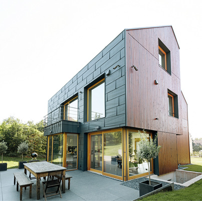 Wechselspiel: dunkle Fassade, helle Fenster, dunkle Laibung und helle Holzfassade
