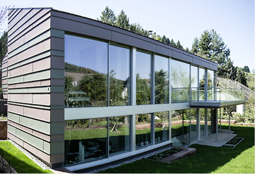 
Das mit pigmentiertem Titanzink bekleidete Wohnhaus fügt sich dank seines Farbdesigns perfekt in das Umfeld ein
