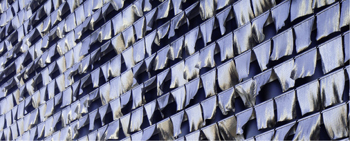 
Chain of Ether: Kleine Quadrate aus besonders leichtem Aluminiumgeflecht reagieren auf den Windhauch aus der Lüftungsanlage eines Gebäudes
