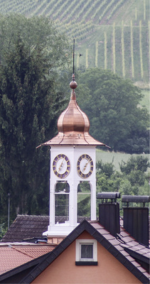 



Umrahmt von sanften Hügeln und Weinbergen liegt Vögisheim im Markgräflerland. Der neu eingedeckte Glockenturm des Gemeindesaals überragt die Dächer
