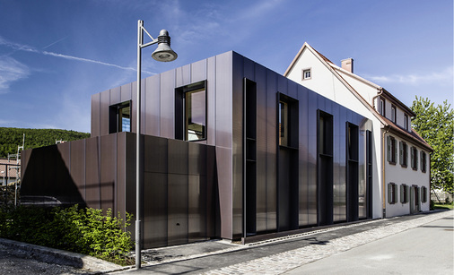 
Kubisch-puristisch und in sich gekehrt präsentiert sich der Neubau auf der Straßenseite
