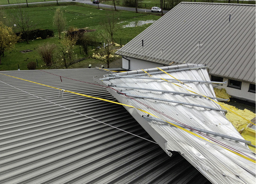 
Das Ausmaß der Schäden: Offenes Dach, verbogene Aluminiumtafeln und gebrochene Tragleisten. Außerdem hatte der Orkan die Dämmfasern weit über die Landschaft verteilt
