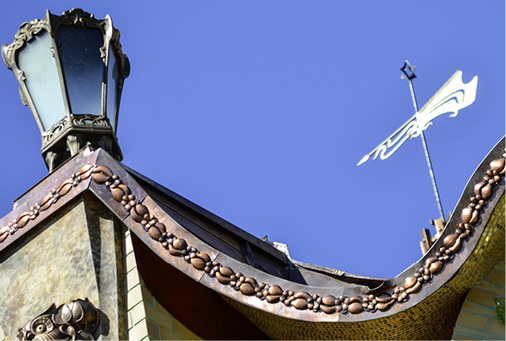 
Das Kupferband mit Blättern und Blütenknospen zieht sich um die obere Etage eines luxuriösen Gebäudes
