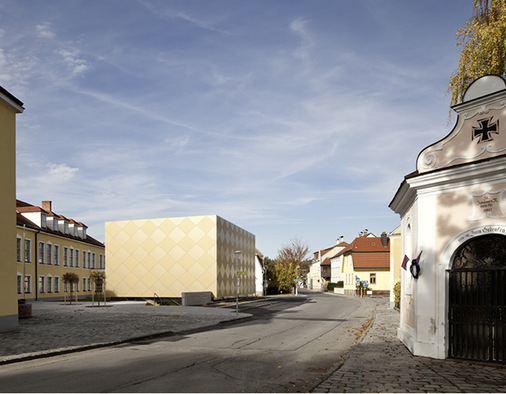 Umgeben von historischen Gebäuden ist der goldene Rauten-Kubus ein echter Hingucker
