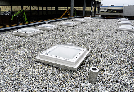 
Das fertige Edelstahlflachdach mit Lichtkuppeln, RWA-Entrauchung und Blitzfängern wurde mit Kiesauflast befüllt

