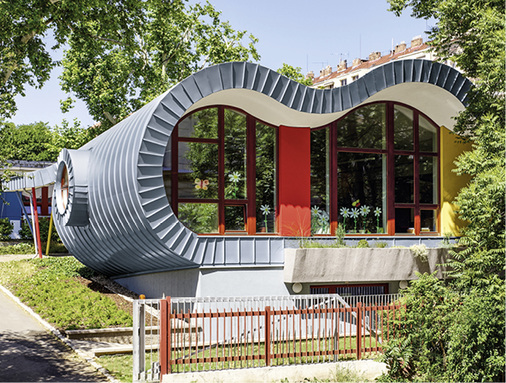 
Blaugraues Titanzink und fröhliche Farben mitten im Grünen machen die Architektur auch für Kinder interessant 
