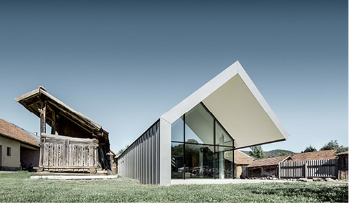 
Die bäuerliche Liegenschaft wurde mit futuristischen Formen, Sichtbeton, großen Glasflächen, Metalldach und -fassaden in ein kreatives Kompetenzzentrum für Architektur fusioniert



