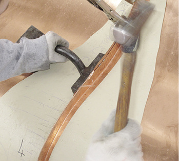 



Handarbeit: Der Falzvorgang mit Schaleisen und Hammer wird vorsichtig ausgeführt. Die Scharoberfläche wird per Abdeckung geschützt
