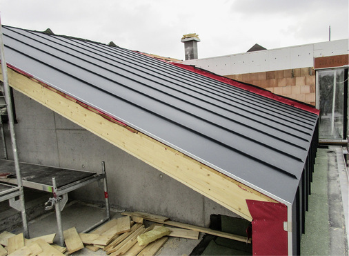 
Geradlinig verlaufende Aluminium-Stehfalzscharen sowie Details an Traufe und Ortgang während der Bauphase 



