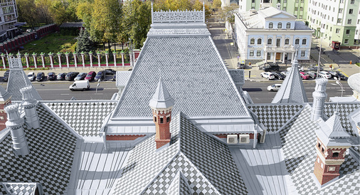 



Die Walmdächer sind mit quadratischen und spitzen, biberschwanzförmigen und zum stilisierten Kreuz geformten Sonderrauten gedeckt, die Satteldächer mit Doppelstehfalzprofilen
