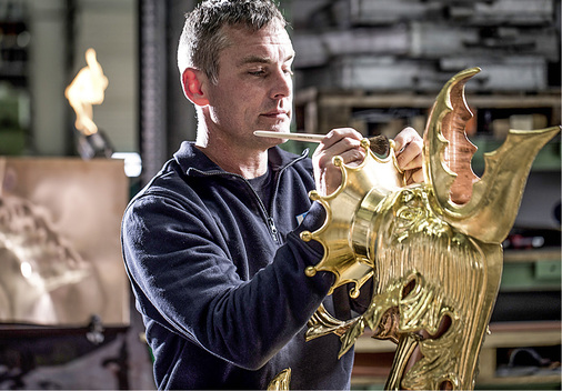 
Ein Kaufmann-Ornamentenspengler vergoldet einen nach historischer Vorlage angefertigten Wasserspeier



