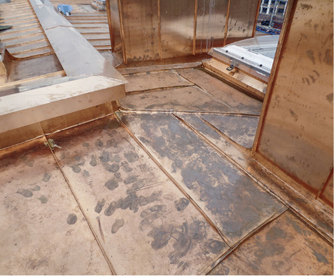 



Maßarbeit: Ein einzelner diagonaler Falz, der an der Eckgaube beginnt, endet zwischen den Schornsteinen und Lichtkuppeln am rechten Winkel des Firstes
