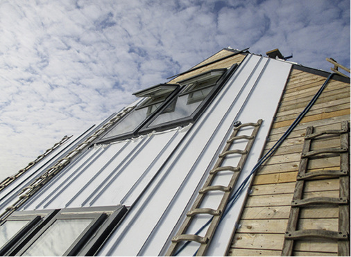 <p>
</p>

<p>
Wo es die Fensteranordnung erlaubte, wurde sowohl auf dem Dach als auch an der Fassade mit durchgehenden Scharen ohne Querteilung gearbeitet. Das schiefergraue Titanzink ist hier noch mit einer Folie geschützt
</p> - © Rheinzink

