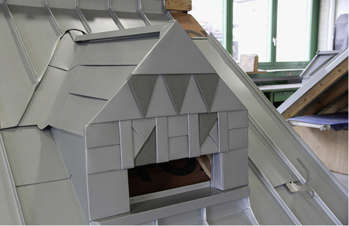 <p>
Verzierte Gaubenfront und abwechslungsreiche Dacheindeckung 
</p>

<p>
</p> - © BAUMETALL

