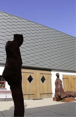 <p>
</p>

<p>
Hölzerne Skulpturen bewachen Hubers mit dreidimensionalen Schindeln bekleidete Flaschnerwerkstatt 
</p> - © BAUMETALL

