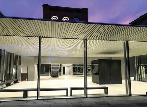 



Fluchtgerechte Sicken entlang der Glasfassade, die den Anschluss zwischen Innendecke und Vordach bildet 
