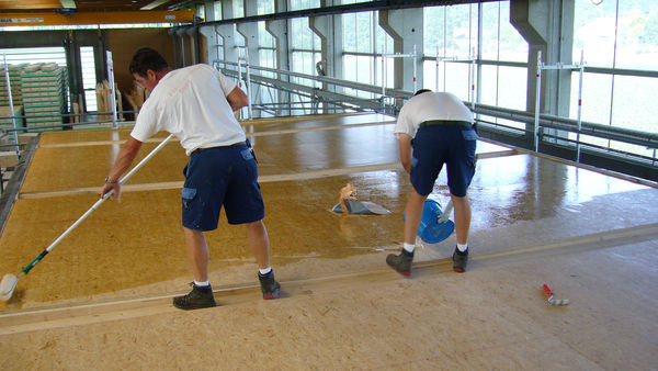 Die Verarbeiter der Firma TR Flachdachbau GmbH applizieren die Grundierung Triflex Cryl Primer 276. - Triflex