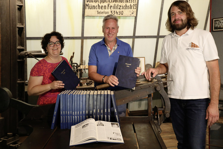 Maria Schechtl, Jens Sperber und Andreas Fella freuen sich im Namen der Stiftung des Europäischen Klempner- und Kupferschmiedemuseums in Karlstadt über zahlreiche ledergebundene BAUMETALL-Jahresausgaben