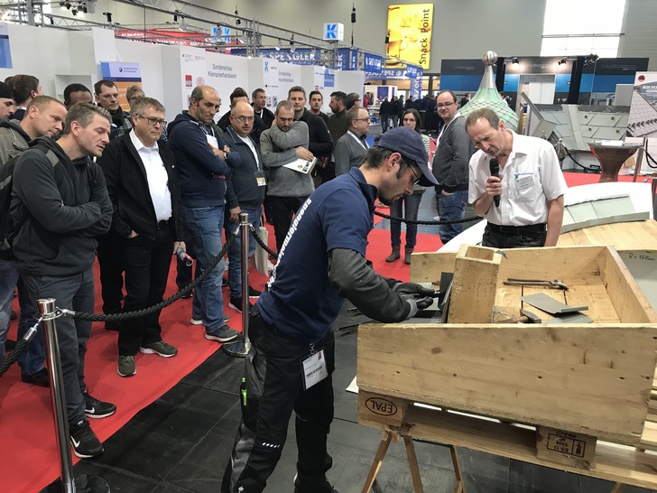 Arno Fell erklärt Messebesuchern den Einbau einer Durchdringung in einem Stehfalzdach