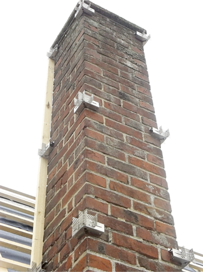 Die Edelstahlecken werden am Schornstein positioniert und mit dem umlaufenden Seil fixiert