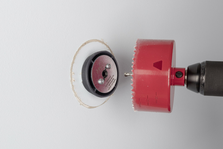 Die Stahlbuchse im Inneren der Aufbohrhilfe hält den Zentrierbohrer der Lochsäge auf Kurs