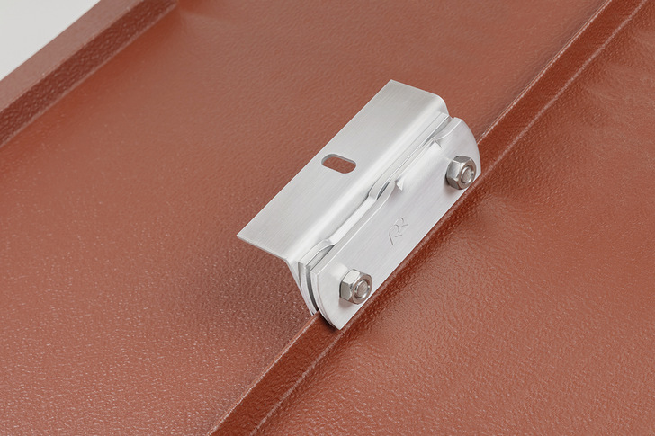 Rees-Solarhalter aus Edelstahl auf einem rot beschichteten Stehfalzdach