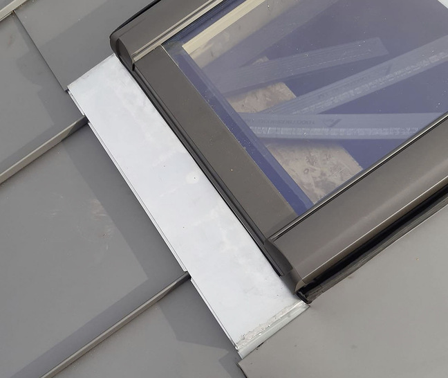Kleines Detail, große Wirkung: Der Eindeckrahmen 
hat im unteren Bereich eine flexible Schürze, 
welche die Ableitung des Wassers auf die Dachplatten 
gewährleistet