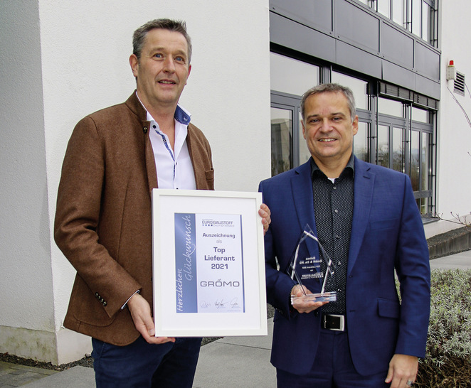 Oliver Oehler (stellv. Bereichsleiter Dach & Fassade/Baumetalle, Eurobaustoff) gratuliert Grömo-Vertriebsleiter Markus Schreck zur Auszeichnung als Top-­Lieferant 2021 - © Bild: Grömo
