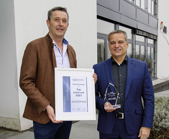 Oliver Oehler (stellv. Bereichsleiter Dach & Fassade/Baumetalle, Eurobaustoff) gratuliert Grömo-Vertriebsleiter Markus Schreck zur Auszeichnung als Top-­Lieferant 2021