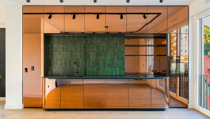 Eine mit Edelstahl bekleidete Einbauküche präsentiert sich in warmem Kupferfarbton