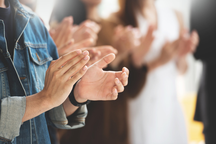 Cropped image of Creative designers audience applauding at a business seminar.
Students standing and clapping in the classroom.