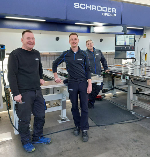 Maschinenbediener Christoph Frölich, Metallbaumeister Marcel Röhr und Maschinen­bediener Maximilian Schubert vor der neuen Schwenkbiegemaschine