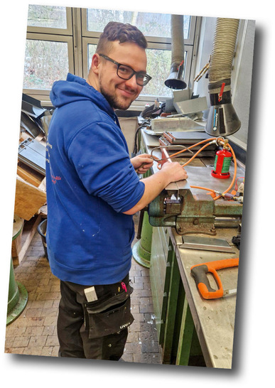 Blick in die Lehrwerkstatt: Nachwuchsklempnerinnen und -klempner beim Herstellen eines Rinnenkessels aus Kupfer