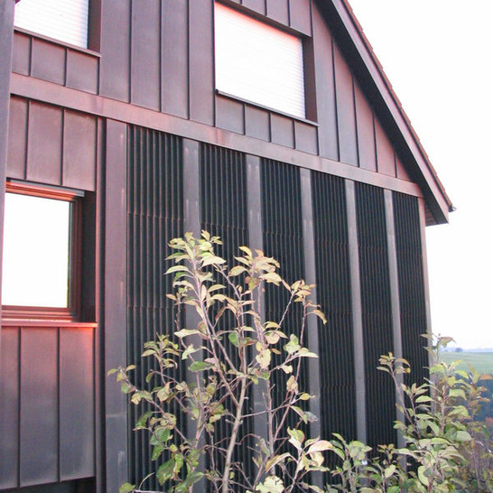 Verdeckt: Die Verrohrung hinter den kupfernen Wandelementen ist von außen nicht zu sehen
