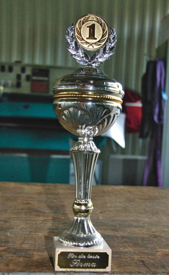 <p>Ein Pokal für den Chef, die Inschrift lautet: „Für die beste Firma“</p> - © Buck