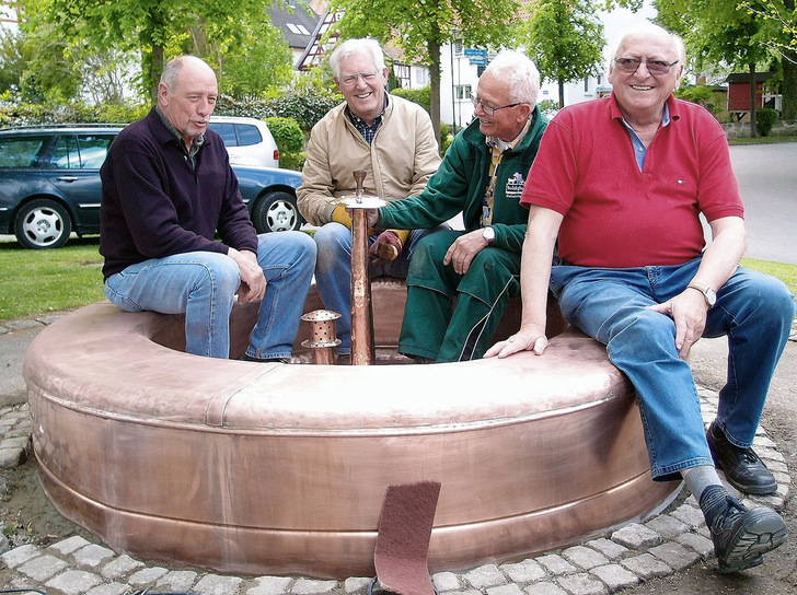 <p>Stolz präsentieren die frisch gebackenen „Kupferschmiede-Gesellen“ um Kupferschmiedemeister Gottlieb Dangel (r.)das neue, aus Kupfer gefertigte Brunnenbecken</p> - © Werner Schulmeyer & Gottlieb Dangel