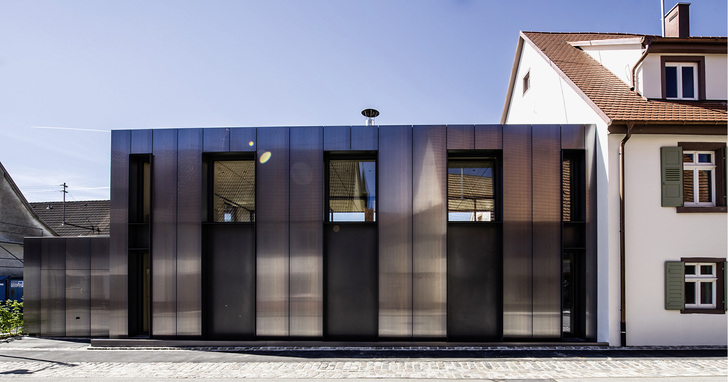 



Der an ein älteres Wohnhaus angeschlossene Neubau mit Garage in eleganter Tecu-Bond-Hülle 
