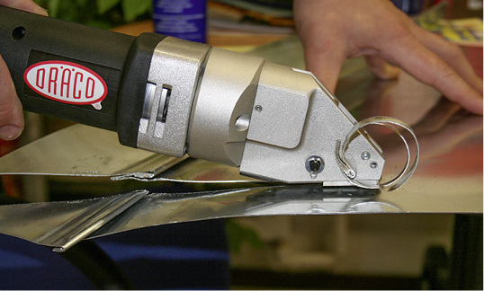 



Die Akku-Falzblechschere Dräco AK3514-2 beim Schneiden über Doppelfalz
