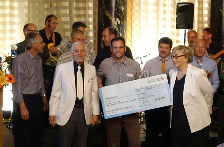 Alex Zehnder und seine Gattin überreichen den Scheck an Sieger Daniel Hunziger (mitte)