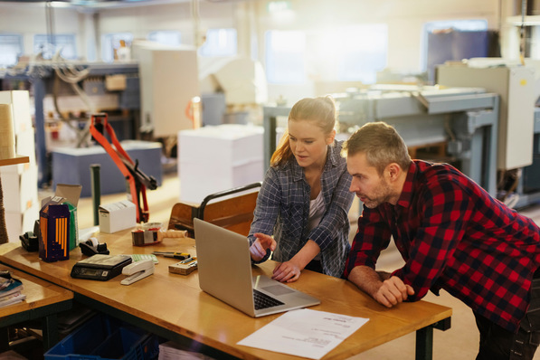 Coworkers working together in a printing press office