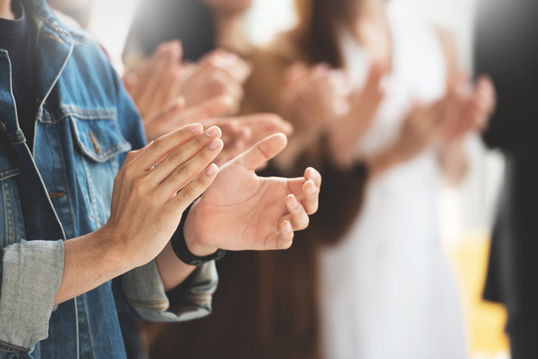 Cropped image of Creative designers audience applauding at a business seminar.Students standing and clapping in the classroom.
